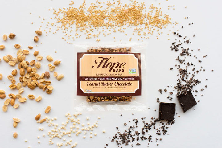 Peanut Butter Chocolate Quinoa bar with peanuts, chocolate, and quinoa in the background