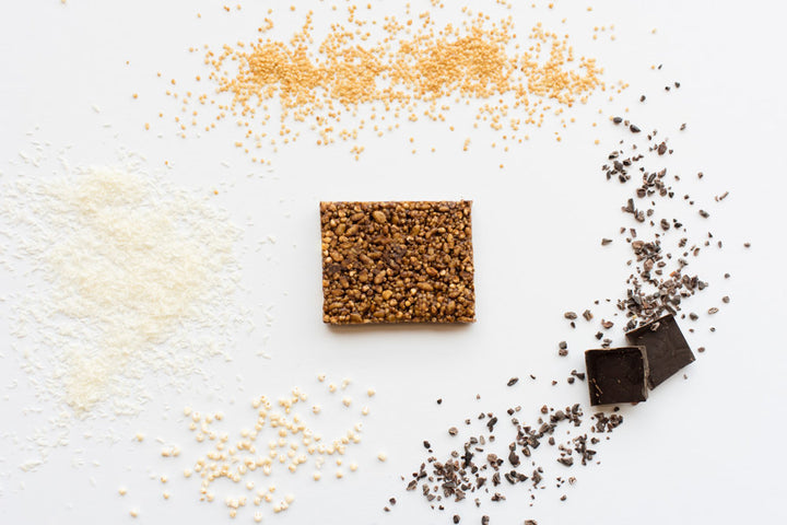 smaller picture of Chocolate Coconut Quinoa Hope bar with chocolate, coconut, and quinoa in background